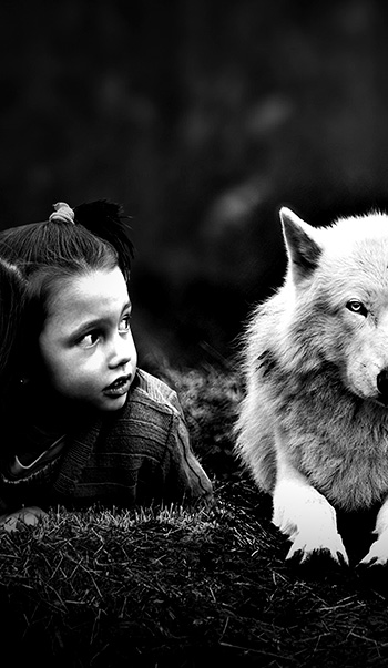 Fotografía creativa niña tumbada con lobo